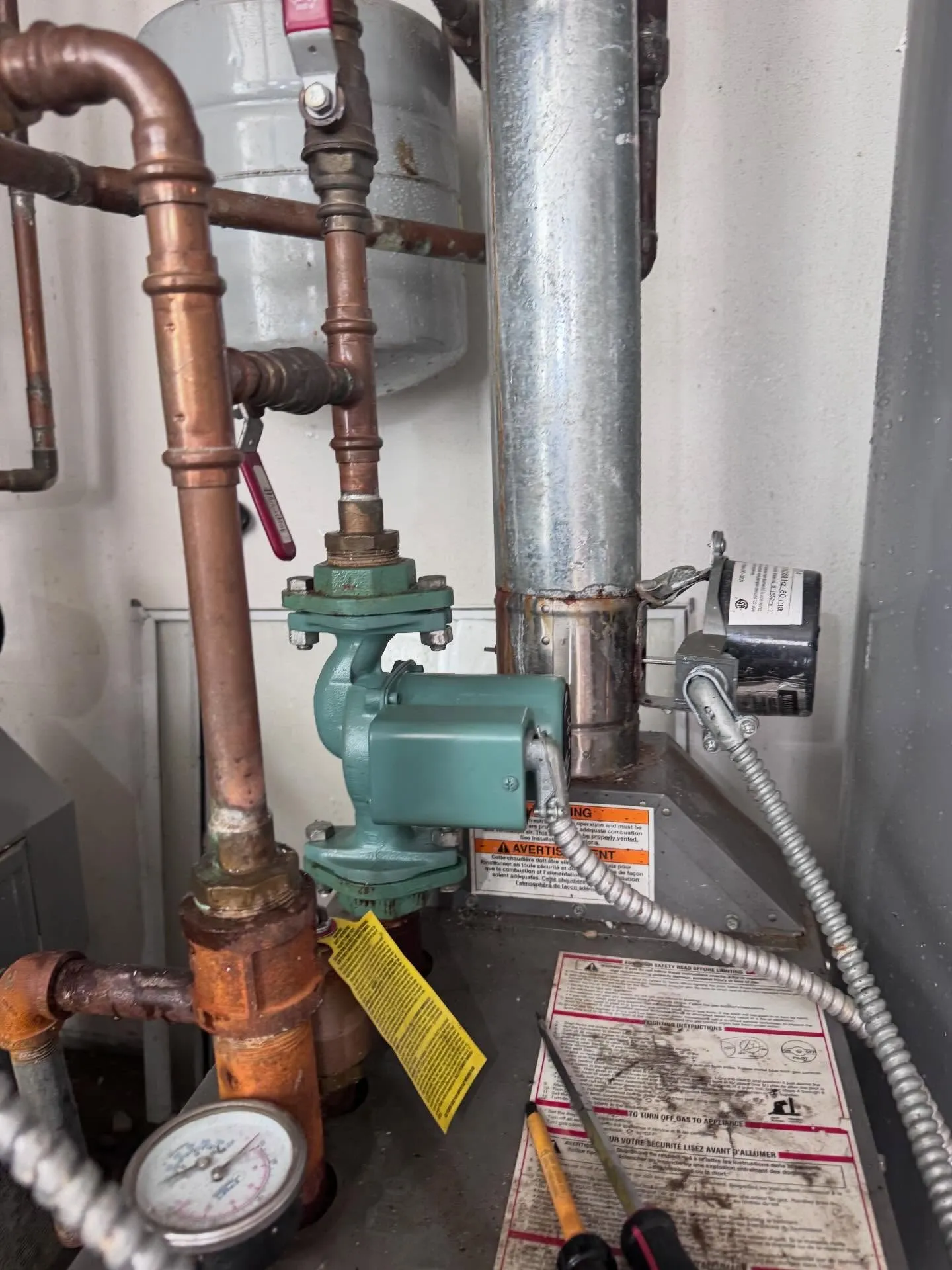 Gas boiler in a South Philadelphia rowhome basement with copper pipes, a teal circulator pump, an expansion tank, and a pressure gauge