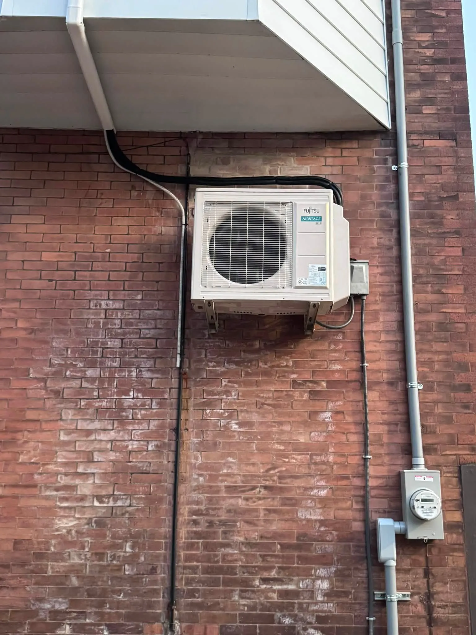 Ductless mini-split condenser mounted cleanly on a South Philadelphia rowhome brick wall