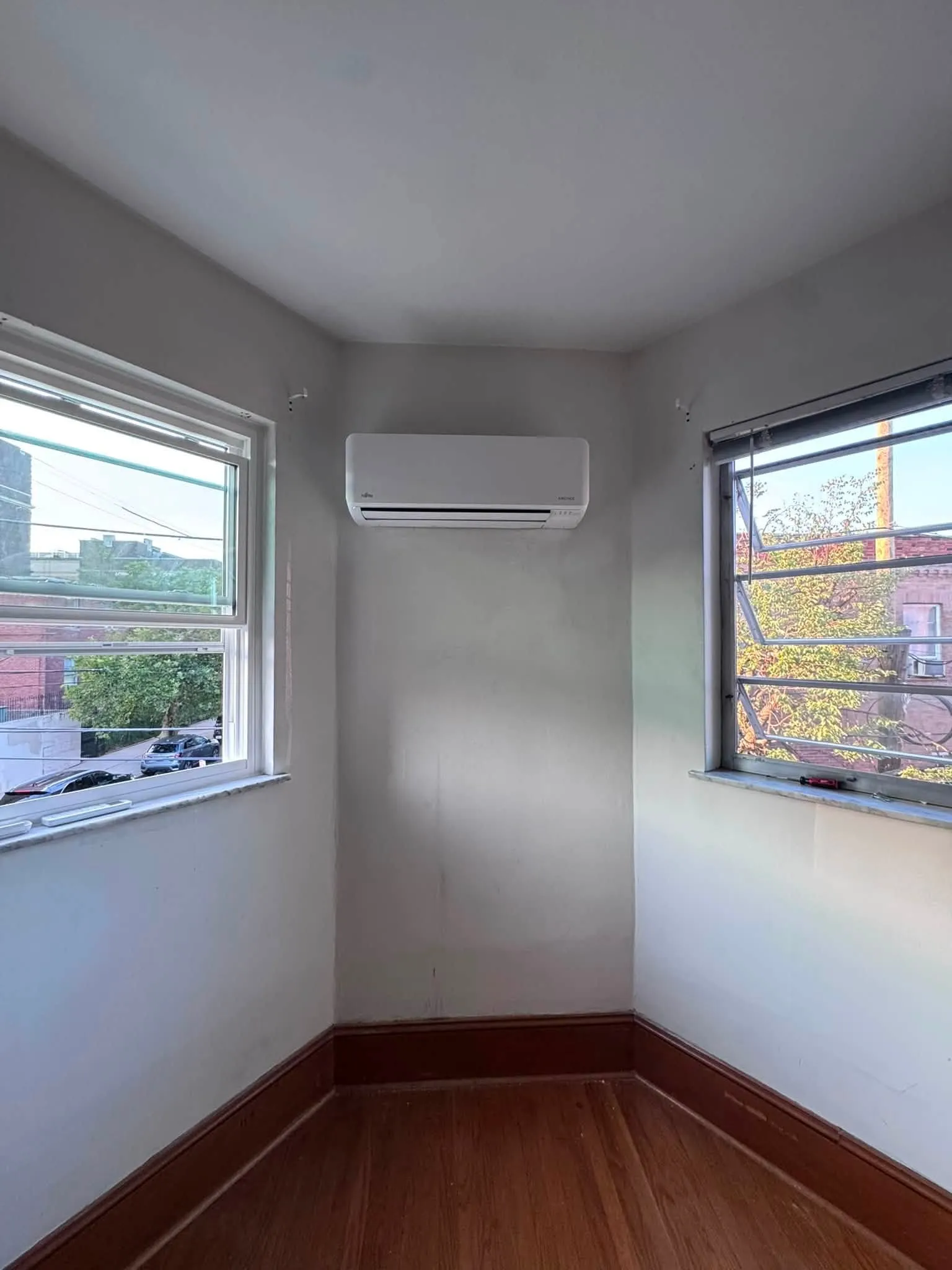 White wall-mounted ductless mini-split head in a sunny South Philadelphia rowhome