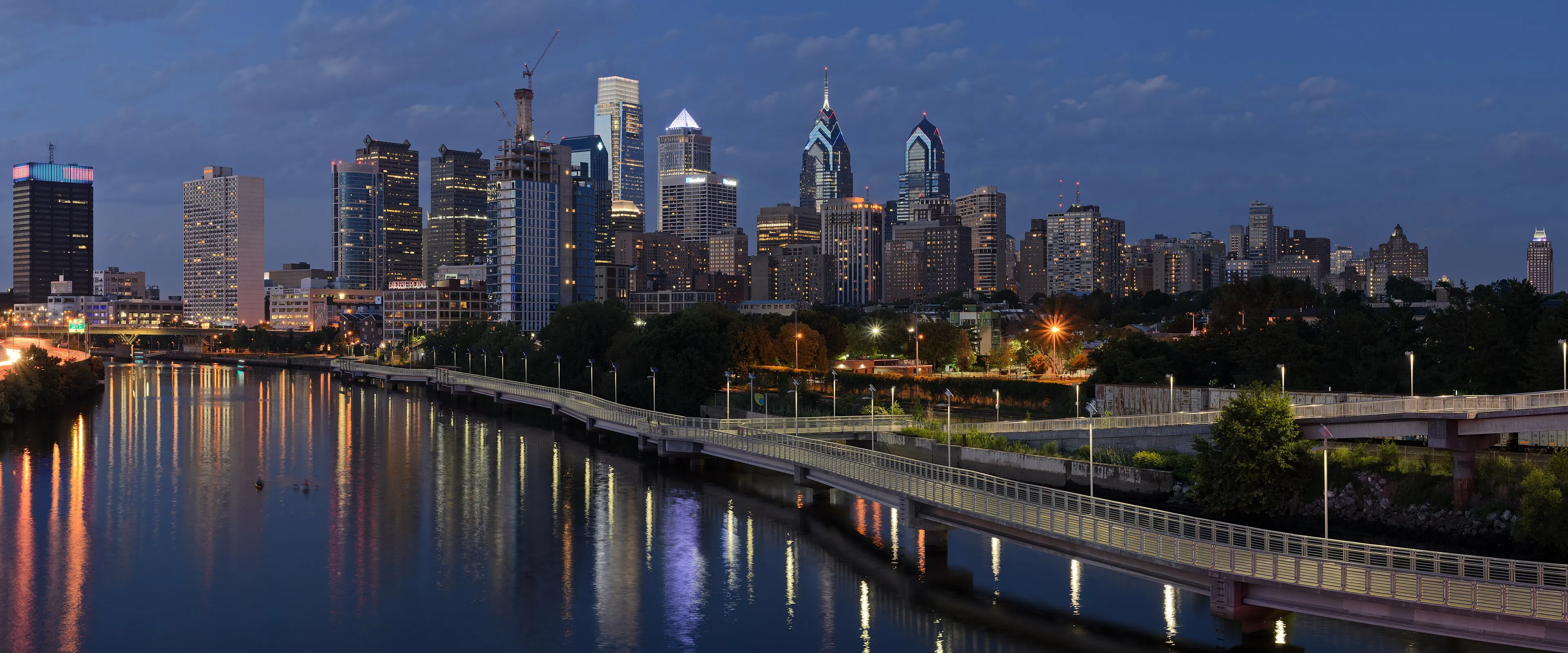 Philadelphia skyline at dusk seen from the South Street Bridge, the northern edge of South Philadelphia, with the Schuylkill River in the foreground
